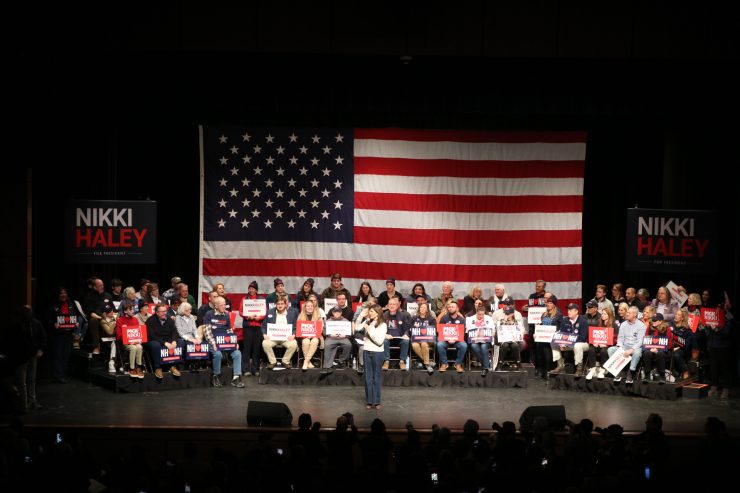 Nikki Haley supports in front of a large American flag on stage at one of her rallies.